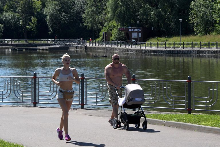 Отдыхающие в парке Олимпийской деревни во время аномальной жары в Москве Отдыхающие в парке Олимпийской деревни во время аномальной жары в Москве