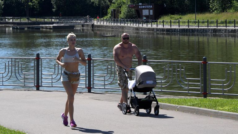 Отдыхающие в парке Олимпийской деревни во время аномальной жары в Москве Отдыхающие в парке Олимпийской деревни во время аномальной жары в Москве