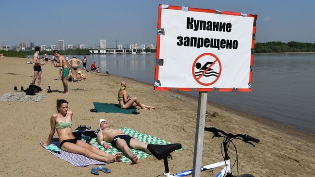 Отдыхающие на пляже реки Обь возле парка Бугринская роща в Новосибирске Отдыхающие на пляже реки Обь возле парка Бугринская роща в Новосибирске