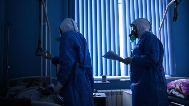 Врачи во время обхода в госпитале для лечения зараженных коронавирусной инфекцией Врачи во время обхода в госпитале для лечения зараженных коронавирусной инфекцией