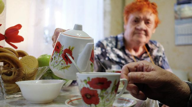 Пожилая семейная пара пьет чай у себя дома Пожилая семейная пара пьет чай у себя дома