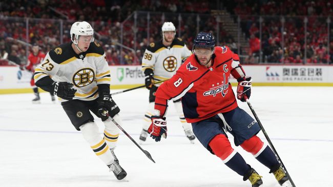 WASHINGTON, DC - DECEMBER 11: Alex Ovechkin #8 of the Washington Capitals skates with the puck past Charlie McAvoy #73 of the Boston Bruins during the second period at Capital One Arena on December 11, 2019 in Washington, DC.   Patrick Smith/Getty Images/AFP