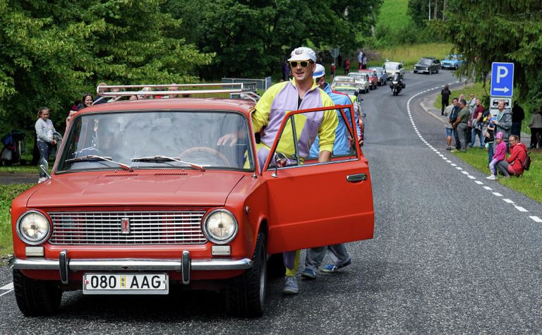 Мужчина садится в автомобиль Lada во время парада по случаю 50-летия марки в городе Вербозе, Эстония Мужчина садится в автомобиль Lada во время парада по случаю 50-летия марки в городе Вербозе, Эстония