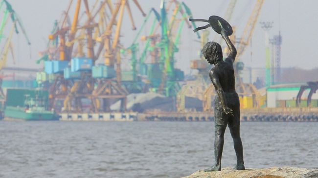 Памятник мальчику с бескозыркой и собакой, который провожает корабли в морском грузовом порту Клайпеды Памятник мальчику с бескозыркой и собакой, который провожает корабли в морском грузовом порту Клайпеды