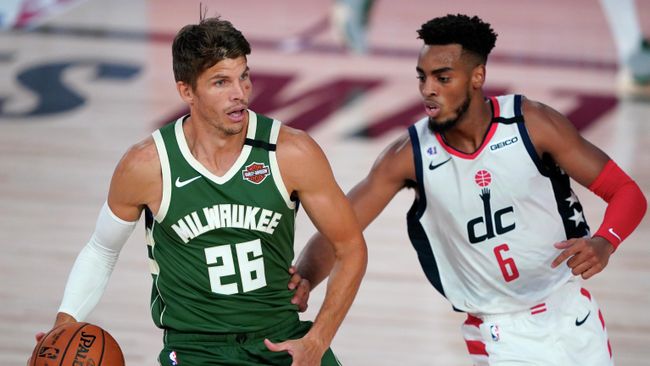LAKE BUENA VISTA, FLORIDA - AUGUST 11: Kyle Korver #26 of the Milwaukee Bucks controls the ball against Troy Brown Jr. #6 of the Washington Wizards during the first half at Visa Athletic Center at ESPN Wide World Of Sports Complex on August 11, 2020 in Lake Buena Vista, Florida. NOTE TO USER: User expressly acknowledges and agrees that, by downloading and or using this photograph, User is consenting to the terms and conditions of the Getty Images License Agreement.   Ashley Landis - Pool/Getty Images/AFP