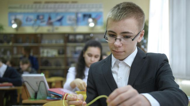 Ученик за партой на уроке по физике Ученик за партой на уроке по физике
