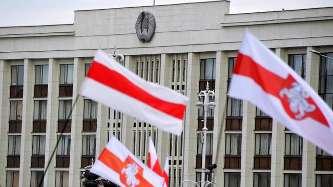 Флаги участников акции протеста на фоне Дома правительства на площади Независимости в Минске Флаги участников акции протеста на фоне Дома правительства на площади Независимости в Минске
