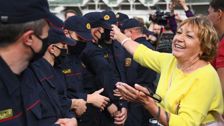 Сотрудники правоохранительных органов и участница акции протеста в Минске