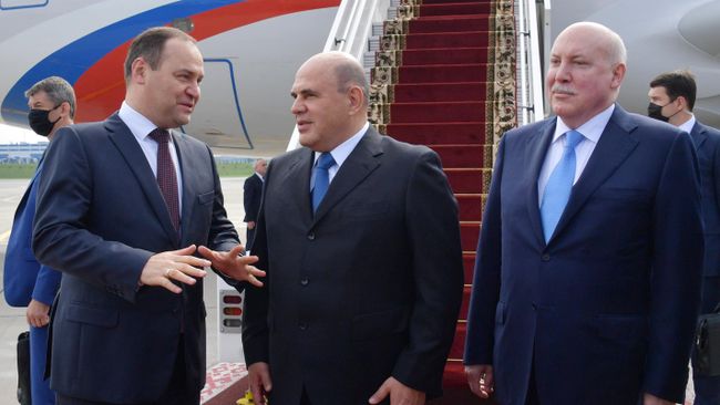 Председатель правительства РФ Михаил Мишустин, премьер-министр Белоруссии Роман Головченко и посол РФ в Белоруссии Дмитрий Мезенцев во время церемонии встречи в аэропорту Минска
