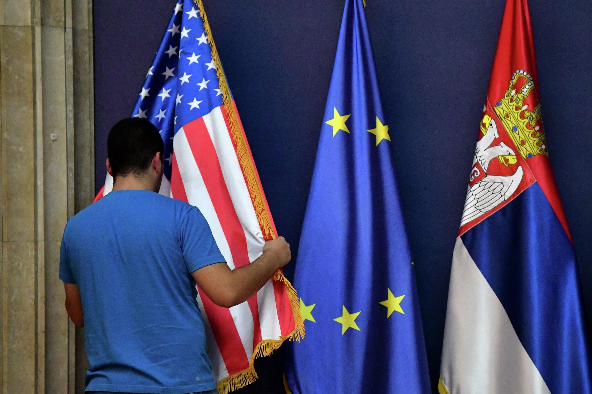 Мужчина расставляет флаг США рядом с флагом Европейского Союза и Сербии Мужчина расставляет флаг США рядом с флагом Европейского Союза и Сербии - РИА Новости, 1920, 07.09.2020