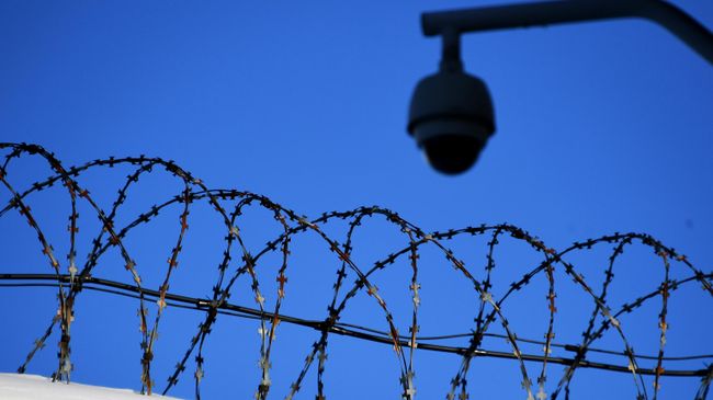 Колючая проволока на ограждении следственного изолятора 
