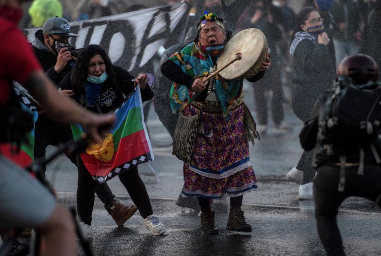 Женщина мапуче во время акции протеста против правительства в связи с пандемией коронавируса в Сантьяго Женщина мапуче во время акции протеста против правительства в связи с пандемией коронавируса в Сантьяго
