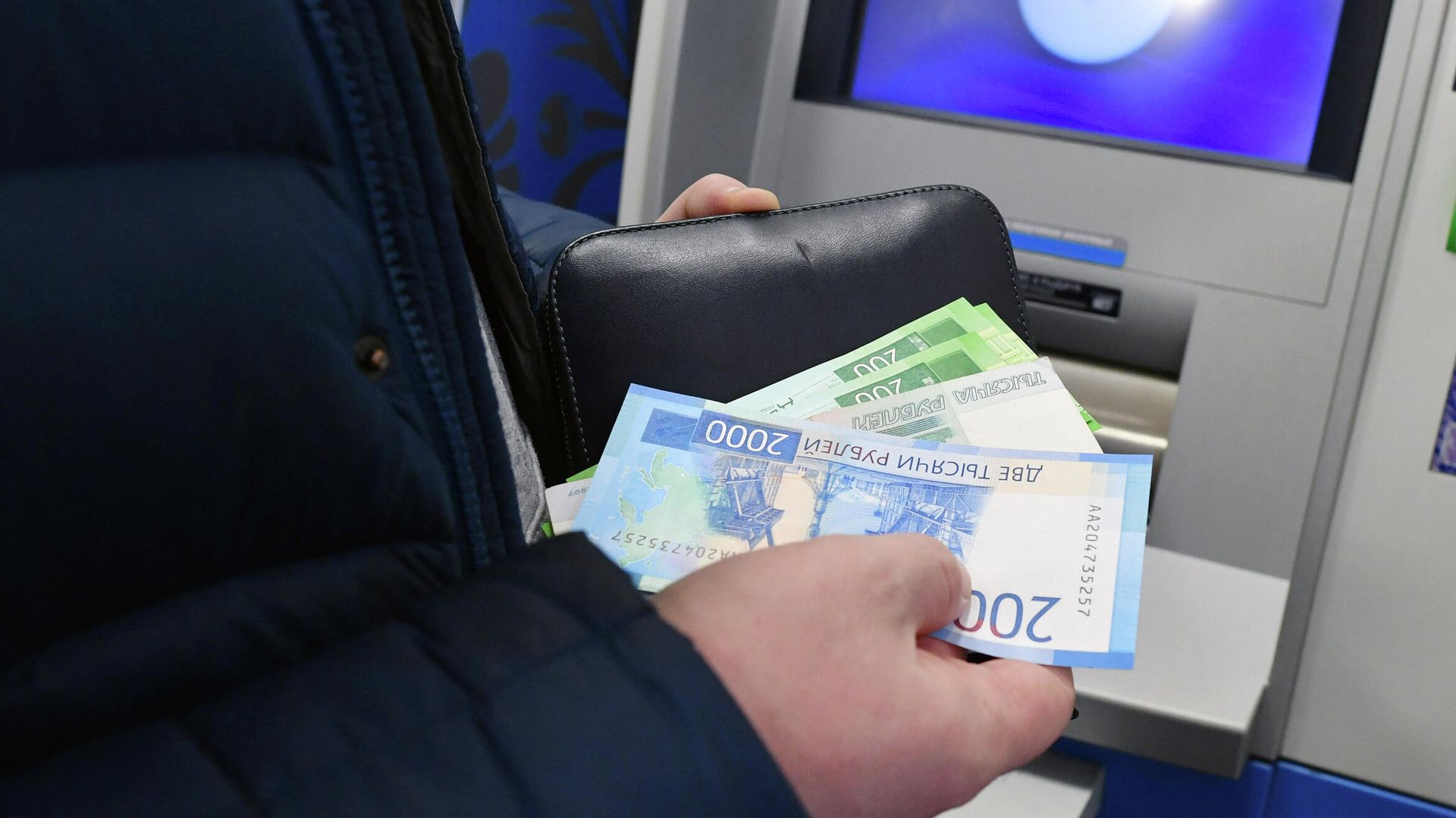Женщина производит снятие денег в банкомате Женщина производит снятие денег в банкомате - РИА Новости, 1920, 29.03.2021