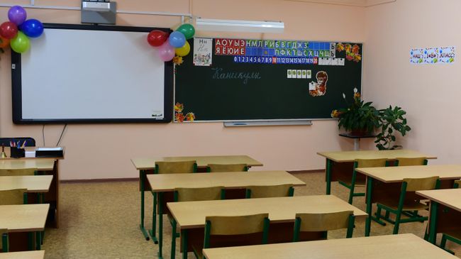 Надпись Каникулы на школьной доске в пустом учебном классе в московской школе