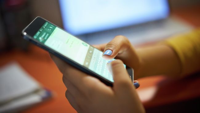 Девушка набирает текстовое сообщение в WhatsApp