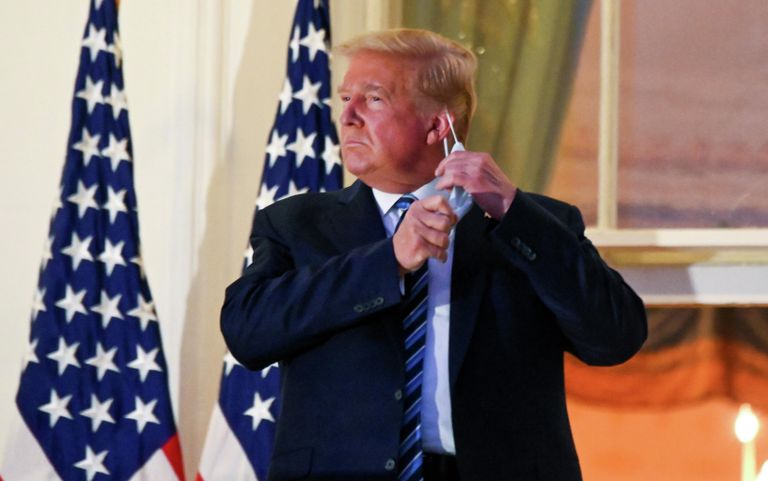 Президент США Дональд Трамп снимает защитную маску на балконе Белого дома после возвращения из национального военно-медицинского центра имени Уолтера Рида