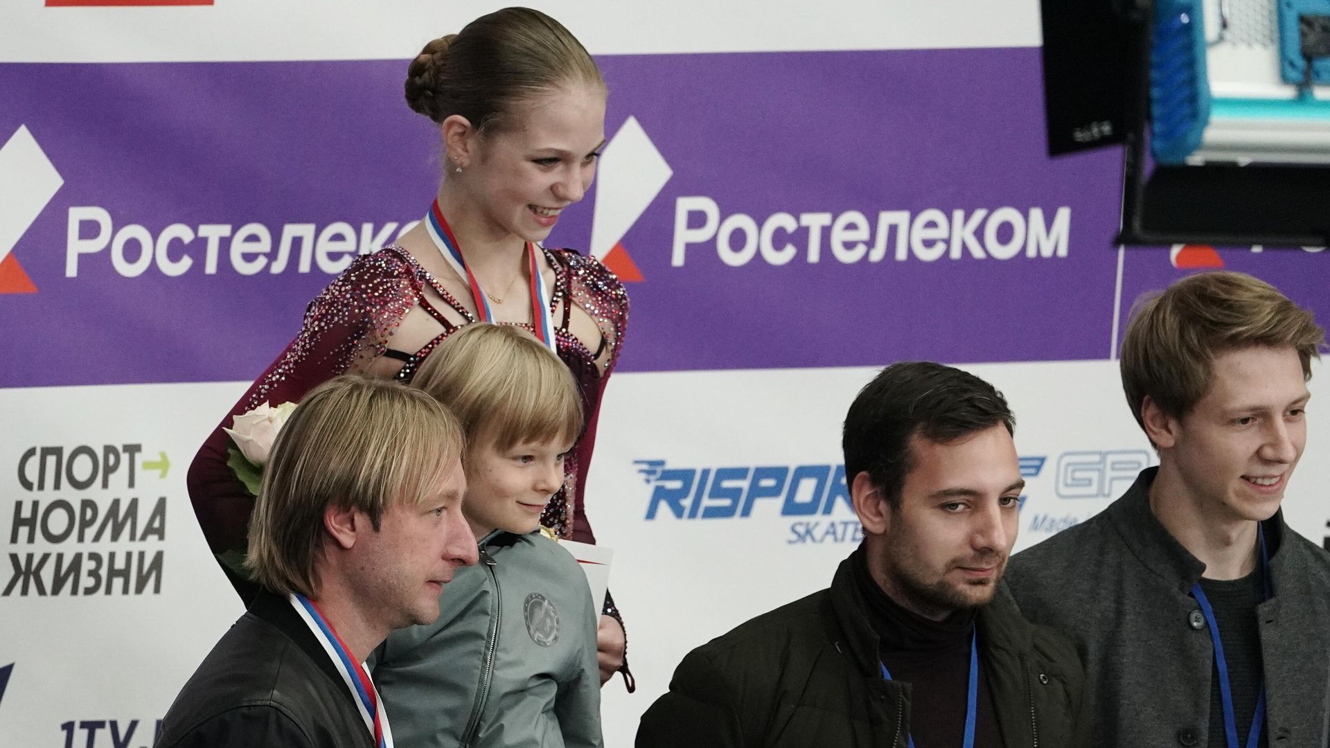 Александра Трусова (в центре на втором плане), Евгений Плющенко с сыном Александром (слева на первом плане) Александра Трусова (в центре на втором плане), Евгений Плющенко с сыном Александром (слева на первом плане) - РИА Новости, 1920, 11.10.2020