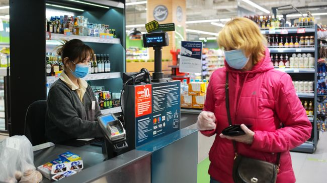 Покупатель оплачивает покупки на кассе в супермаркете Перекресток