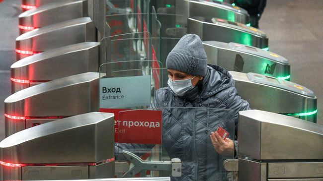 Женщина в защитной маске заходит на одну из станций Московского метрополитена