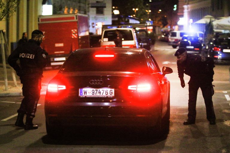 Полицейские проверяют машину на месте происшествия в Вене Полицейские проверяют машину на месте происшествия в Вене