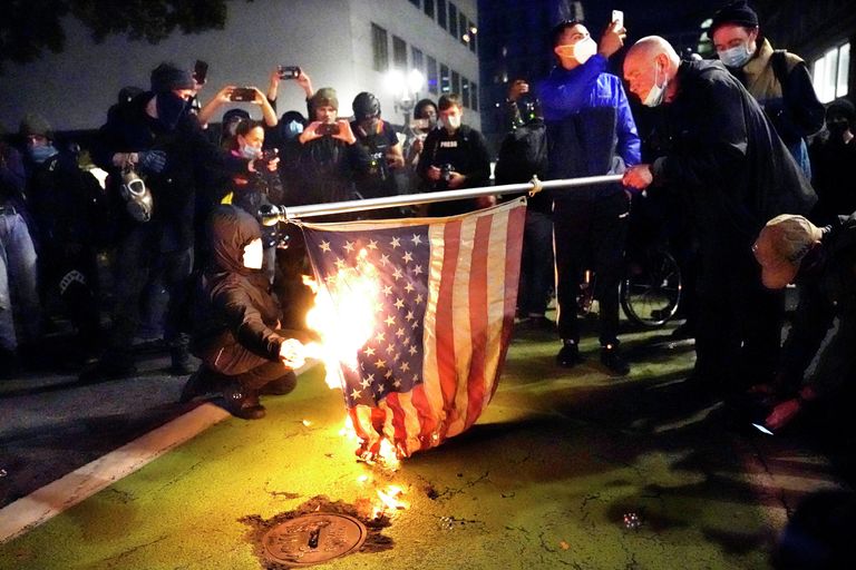Протестующие в Портленде поджигают американский флаг