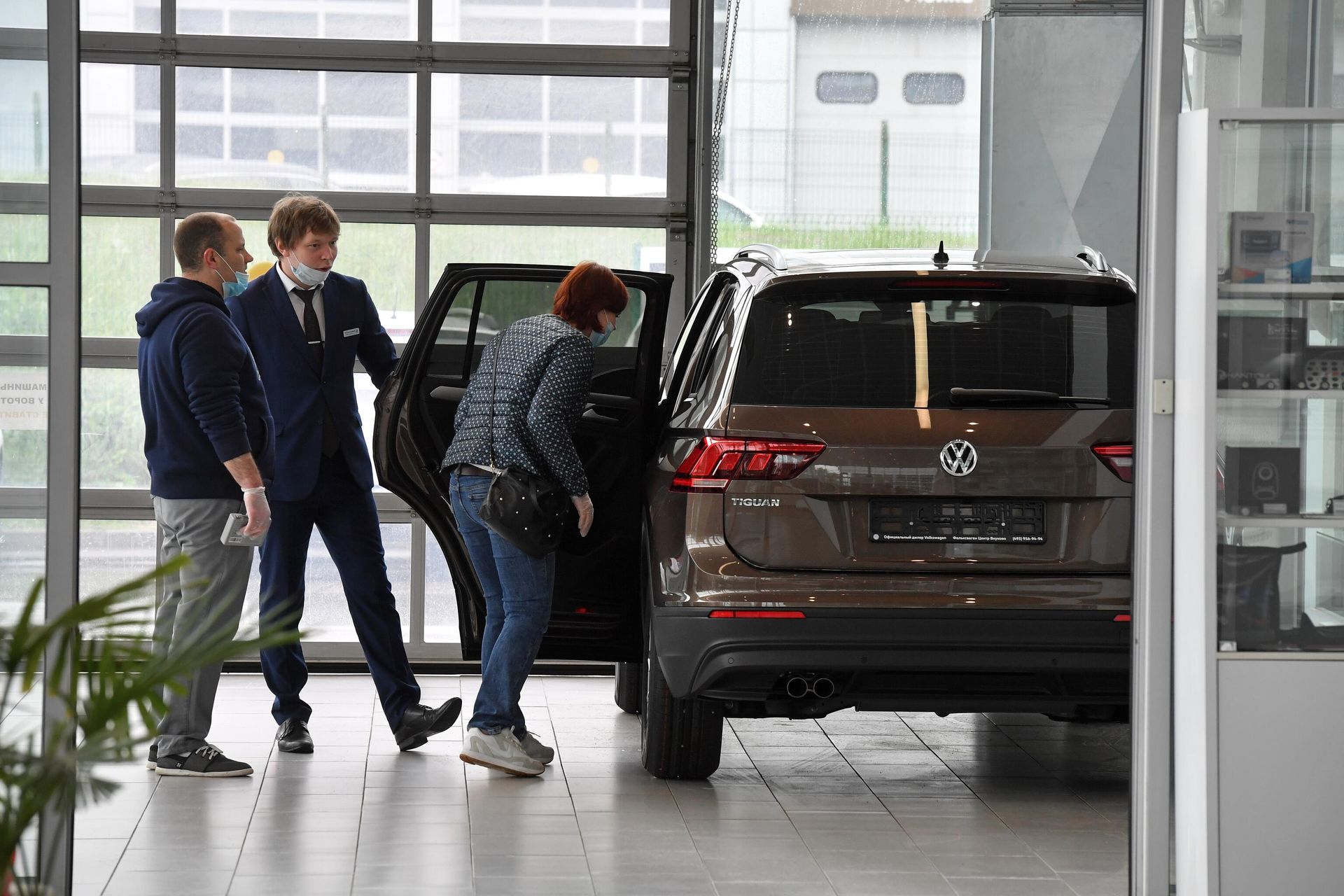Посетители автосалона в Москве осматривают автомобиль Посетители автосалона в Москве осматривают автомобиль
