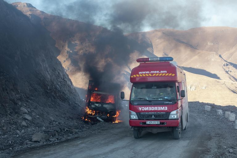 Горящий автомобиль и автомобиль скорой помощи на горной дороге в районе города Карвачар Горящий автомобиль и автомобиль скорой помощи на горной дороге в районе города Карвачар