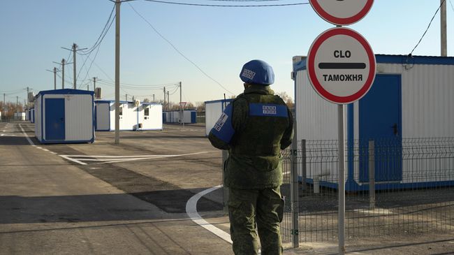Сотрудник СЦКК на контрольном пункте въезда-выезда Луганск - Счастье у линии соприкосновения в Донбассе