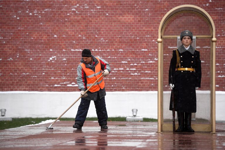 Мужчина убирает снег у Могилы Неизвестного Солдата у стен Московского Кремля Мужчина убирает снег у Могилы Неизвестного Солдата у стен Московского Кремля