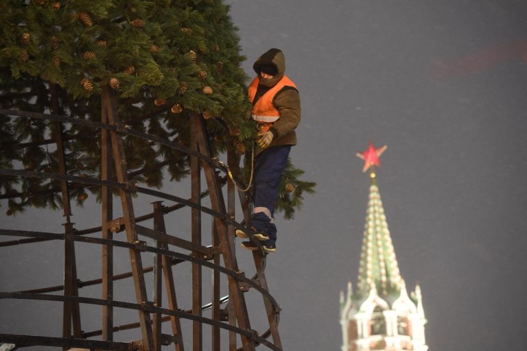 Рабочий устанавливает новогоднюю елку на Красной площади в Москве Рабочий устанавливает новогоднюю елку на Красной площади в Москве