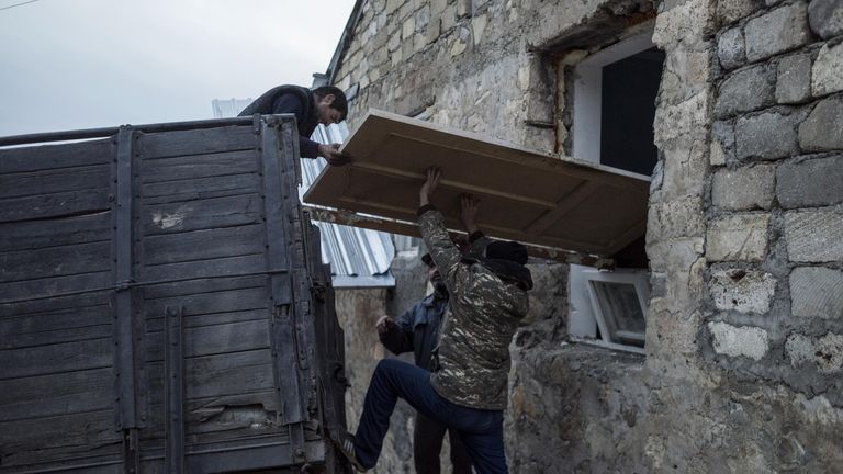 Мужчины загружают дверь в кузов грузового автомобиля в поселке Карегах в Нагорном Карабахе Мужчины загружают дверь в кузов грузового автомобиля в поселке Карегах в Нагорном Карабахе
