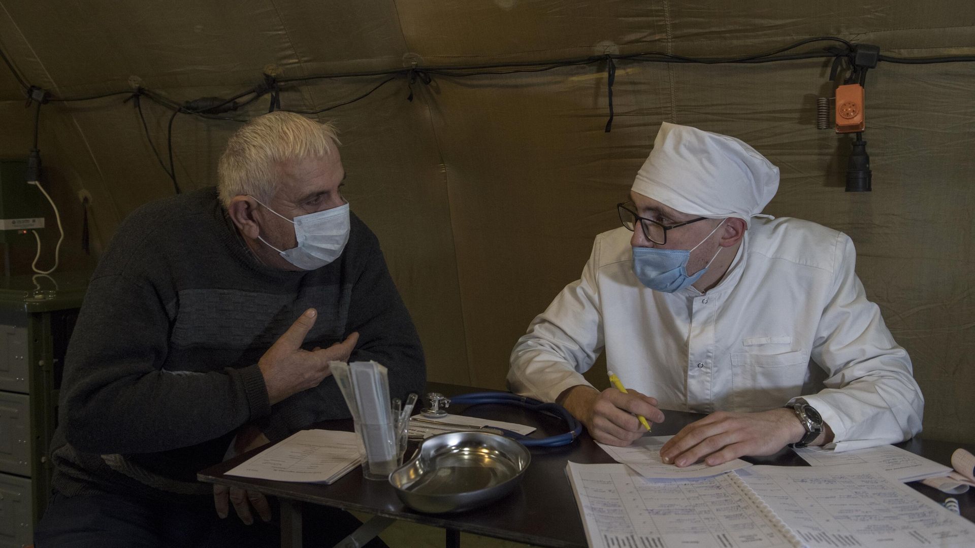 Врач проводит прием пациента на базе госпиталя развернутого Министерством обороны России на территории аэропорта в Степанакерте - РИА Новости, 1920, 10.12.2020
