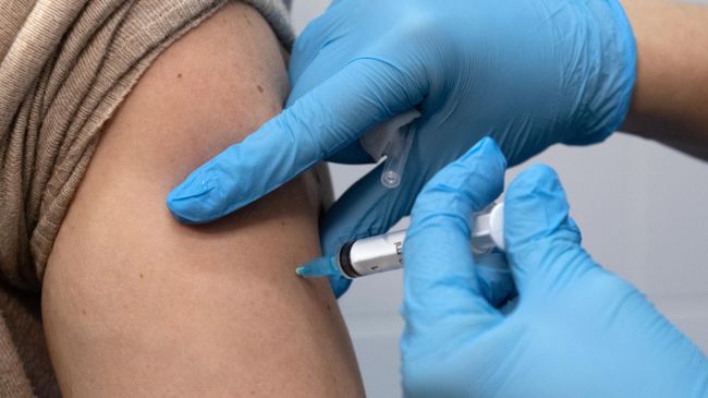 Медработник вводит вакцину в прививочном пункте по вакцинации от COVID-19