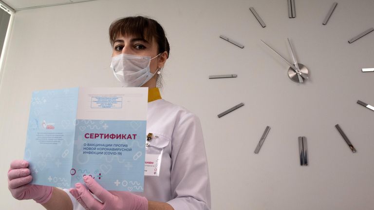 Медработник демонстрирует Сертификат о вакцинации от новой коронавирусной инфекции COVID-19