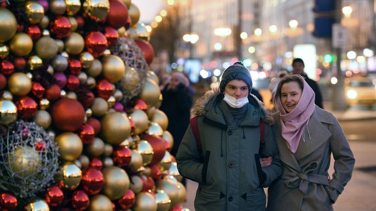 Прохожие возле новогодней ёлки у мэрии Москвы на Тверской улице в Москве Прохожие возле новогодней ёлки у мэрии Москвы на Тверской улице в Москве