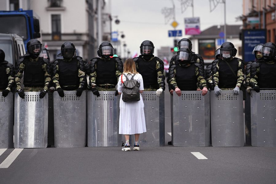 Участница несанкционированной акции оппозиции Марш единства и сотрудники милиции на улице в Минске Участница несанкционированной акции оппозиции Марш единства и сотрудники милиции на улице в Минске