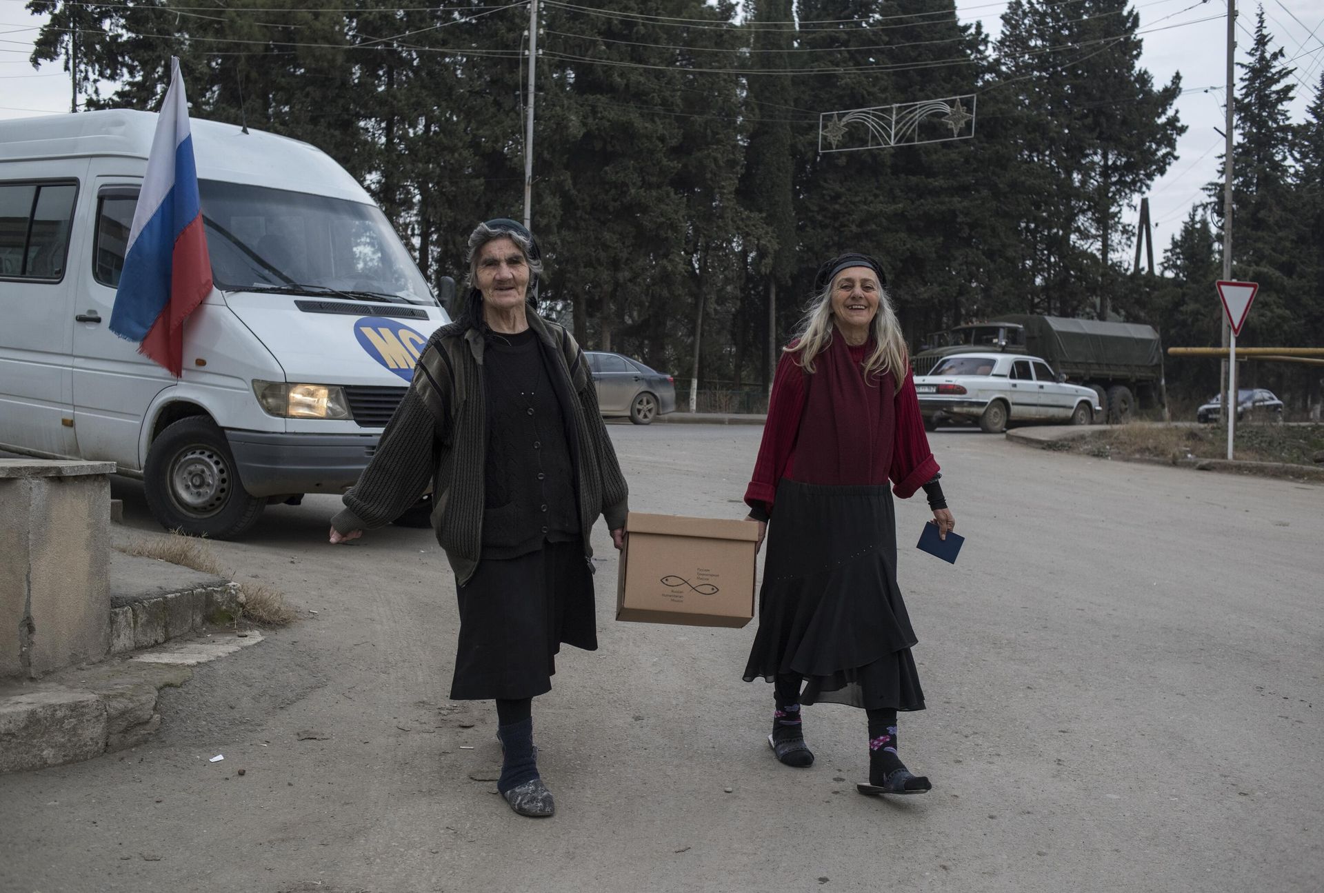 Местные жители несут домой коробку с гуманитарной помощью в городе Мартакерт в Нагорном Карабахе Местные жители несут домой коробку с гуманитарной помощью в городе Мартакерт в Нагорном Карабахе - РИА Новости, 1920, 16.12.2020