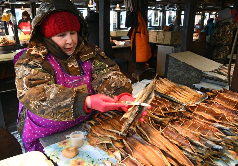 Женщина продает омуль на рыбном рынке в Листвянке Женщина продает омуль на рыбном рынке в Листвянке