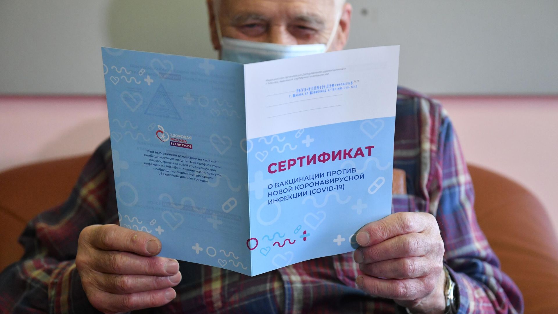Мужчина держит в руках сертификат о вакцинации против коронавирусной инфекции (COVID-19) - РИА Новости, 1920, 03.03.2021
