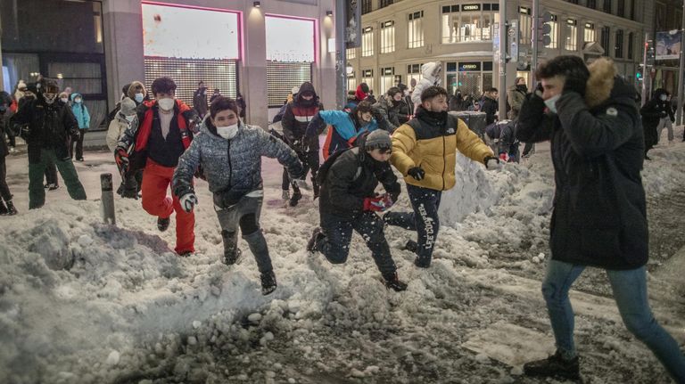 Люди играют в снежки на площади Кальяо в Мадриде Люди играют в снежки на площади Кальяо в Мадриде