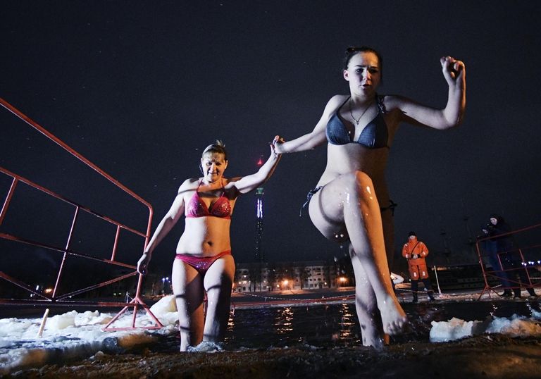 Женщины выходят из крещенской купели на реке Волхов в Великом Новгороде Женщины выходят из крещенской купели на реке Волхов в Великом Новгороде
