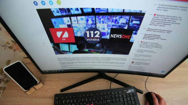 Экран монитора с новостной статьей о закрытии на территории Украины телеканалов 112.Украина, NewsOne и ZIK