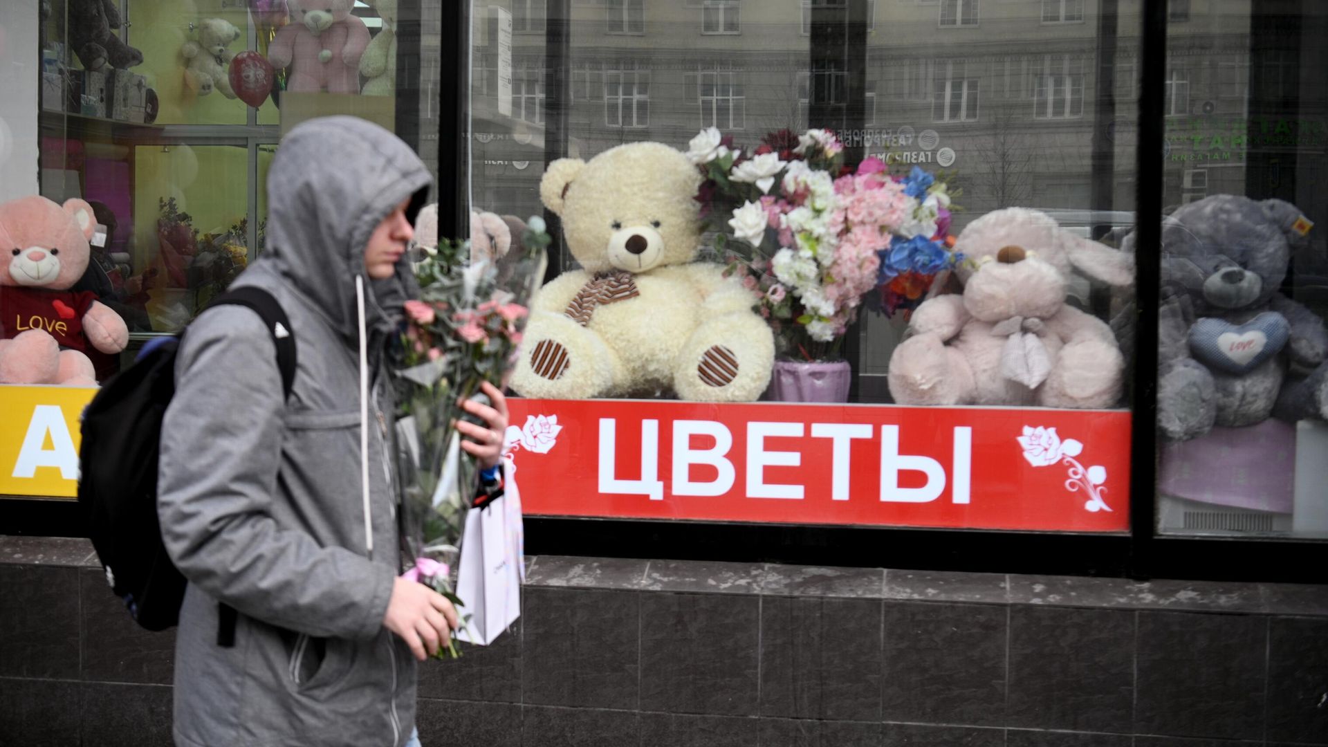 Молодой человек проходит мимо витрины магазина с сувенирной продукцией ко Дню Святого Валентина Молодой человек проходит мимо витрины магазина с сувенирной продукцией ко Дню Святого Валентина - РИА Новости, 1920, 11.02.2021