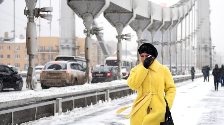 Девушка идет по Крымскому мосту во время снегопада в Москве Девушка идет по Крымскому мосту во время снегопада в Москве