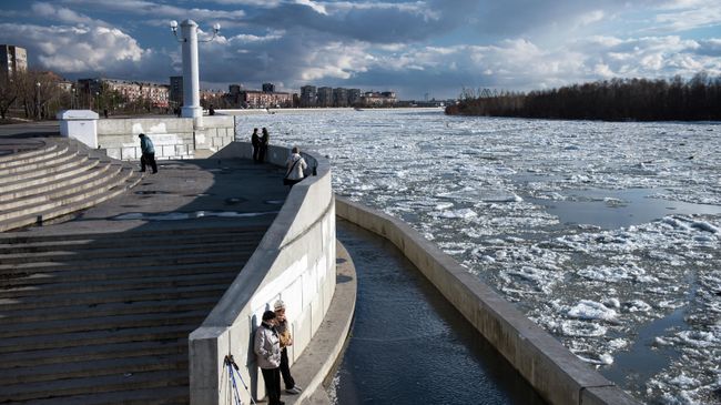 Прохожие на набережной во время ледохода на реке Иртыш в Омске