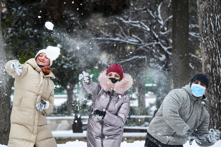 Прохожие играют в снежки на одной из улиц в Баку во время снегопада Прохожие играют в снежки на одной из улиц в Баку во время снегопада