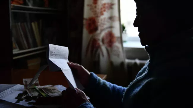 Женщина держит в руках квитанцию ЖКХ