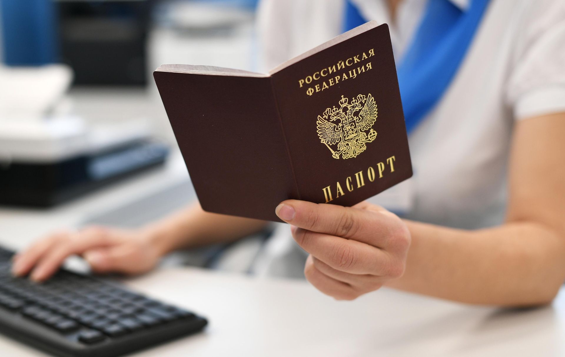 Сотрудник пенсионного фонда держит в руках паспорт России Сотрудник пенсионного фонда держит в руках паспорт России - РИА Новости, 1920, 24.01.2022