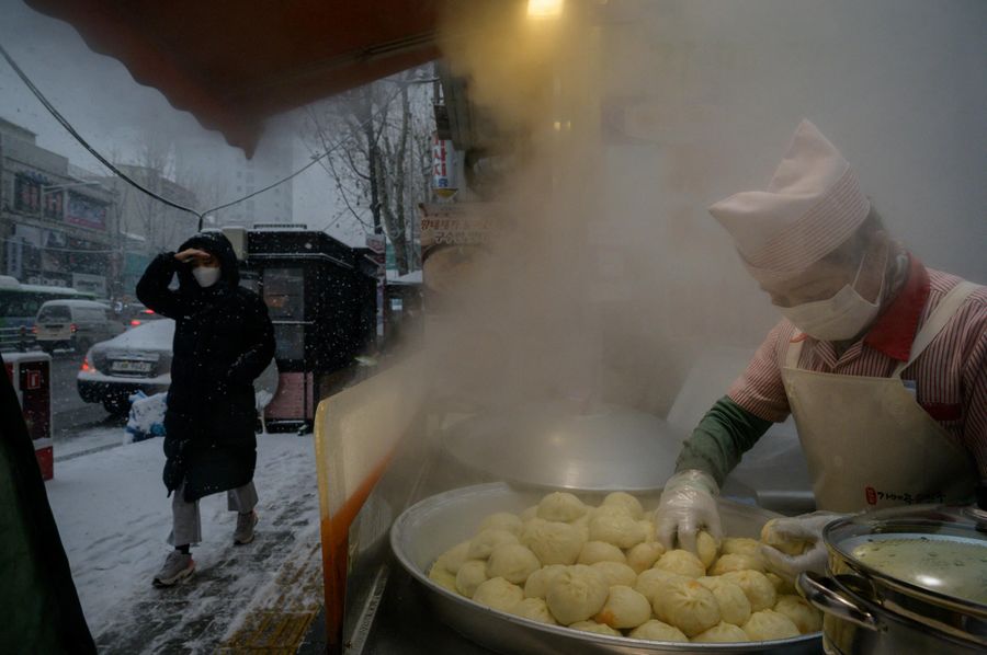 Уличный торговец готовит дамплинги в Сеуле, Южная Корея Уличный торговец готовит дамплинги в Сеуле, Южная Корея