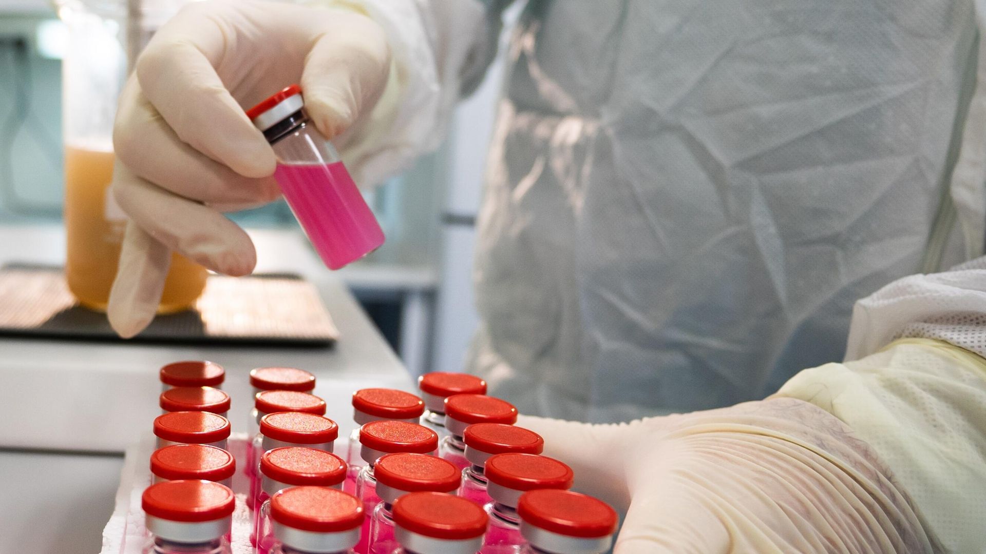 Лаборант демонстрирует емкость с вакциной против COVID-19 для животных Карнивак-Ков - РИА Новости, 1920, 30.04.2021